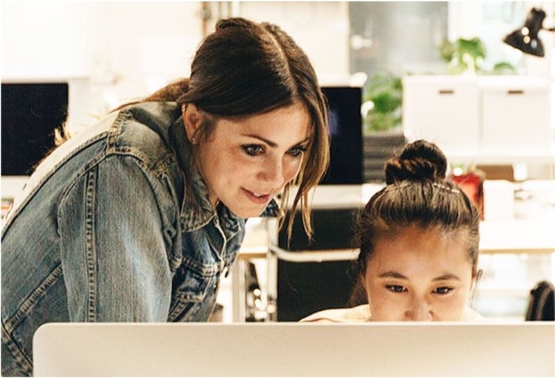 Two women using a desktop computer to create an automated marketing funnel