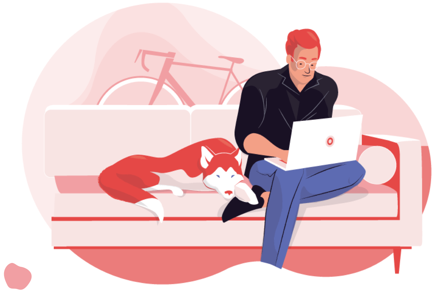 A man using a laptop computer, sitting on a couch next to his pet dog.