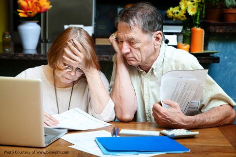 elderly couple with high energy bills and laptop in front