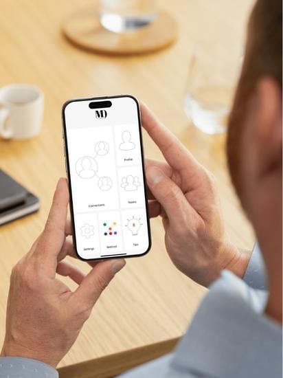 Person holding cell phone with MD App showing on the screen.