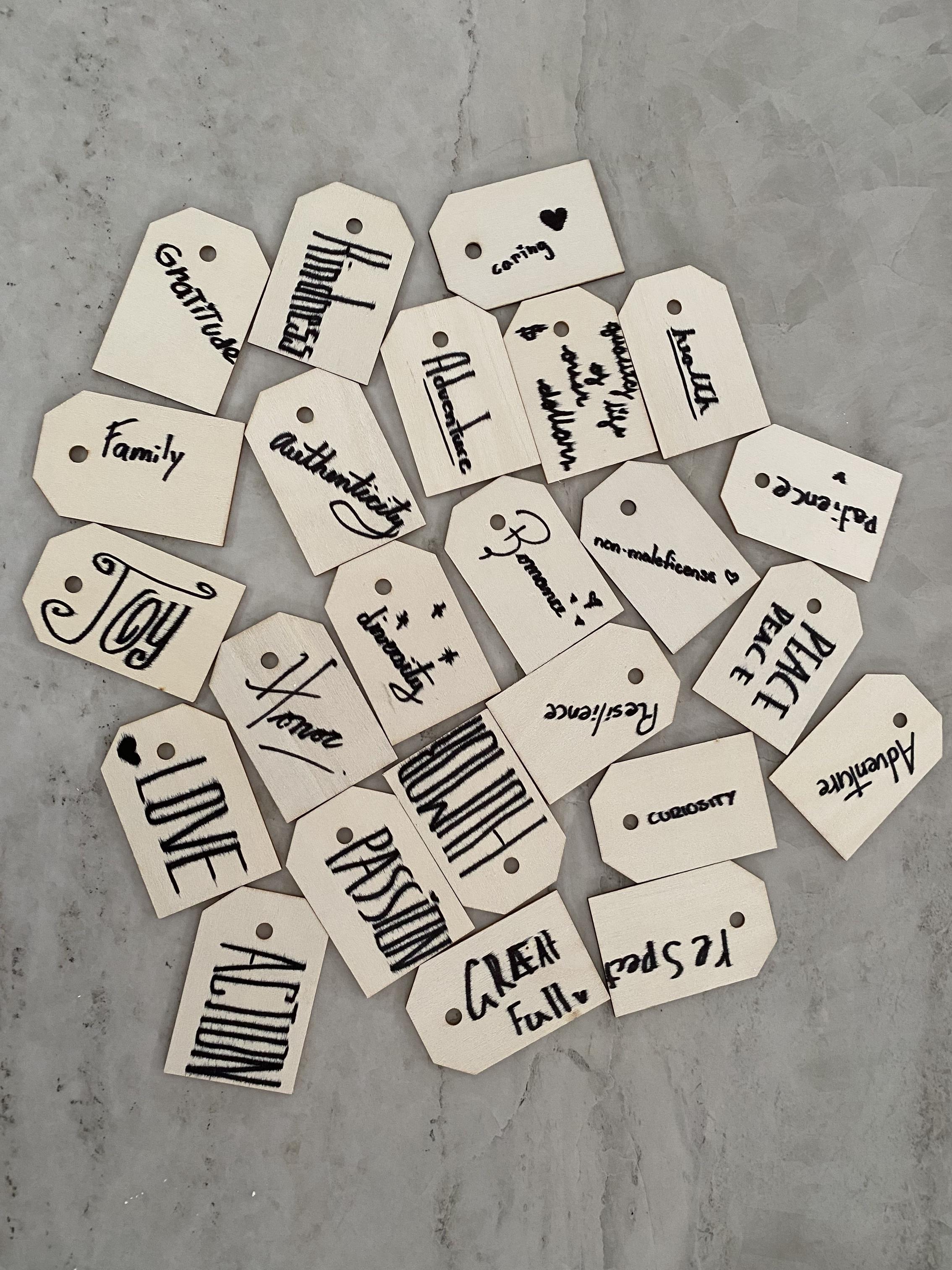 Hand-lettered wooden luggage tags, each carrying one family value