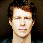 Portrait of Matt Thomson with a straight face on a brown background