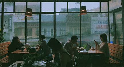 Busy people inside a cafe while it is raining outside