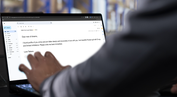 A bearded male wearing a yellow checkered polo holding a cup of coffee and a bright light reflecting on his face from his cellphone