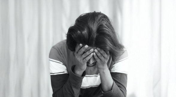 Male wearing a glasses and a hoodie in a coughing gesture