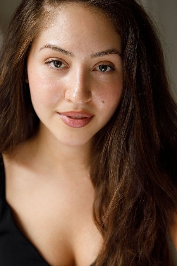 Woman with a long brown hair wearing a black blouse