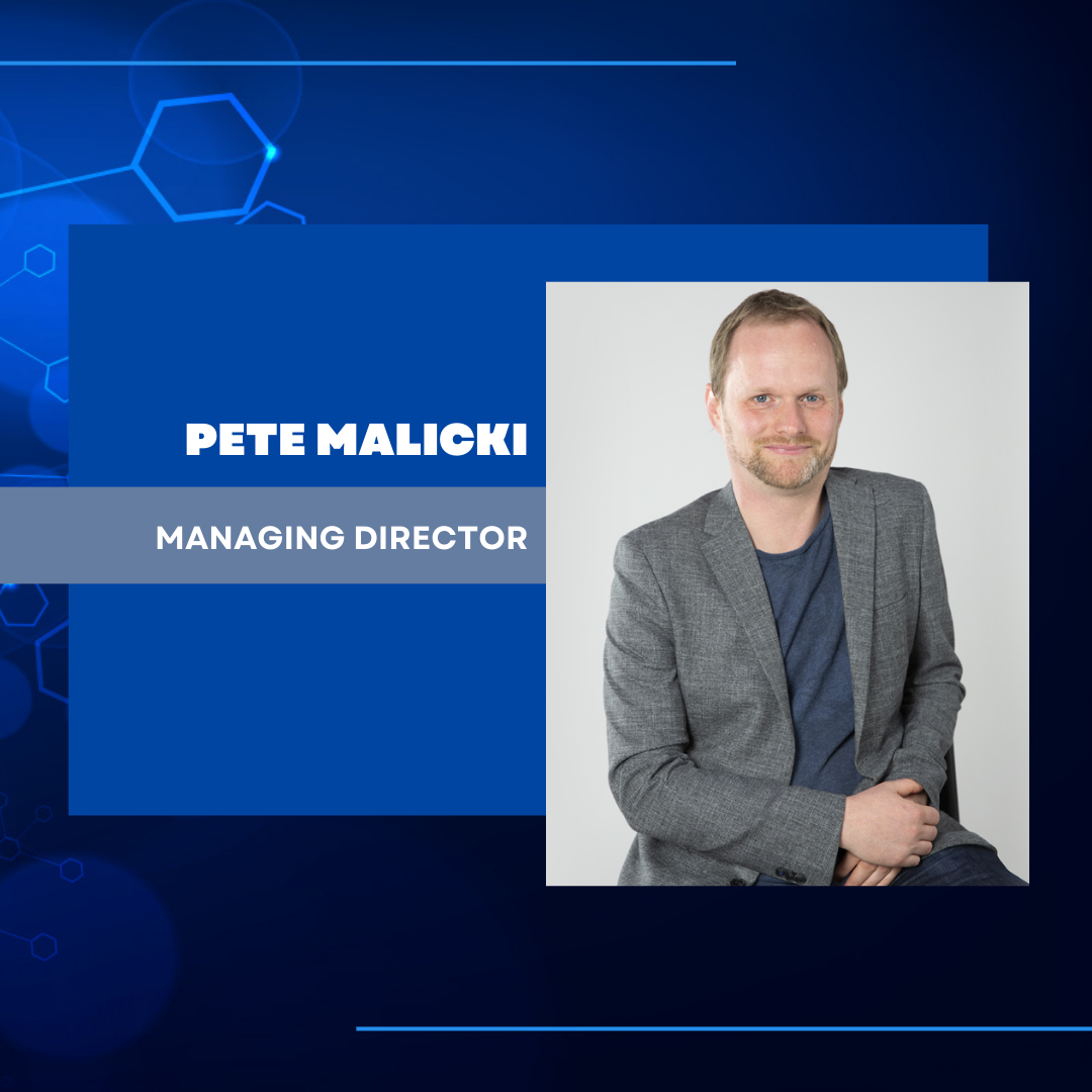 Pete Malicki wearing a grey coat and dark blue shirt in a blue technology abstract background