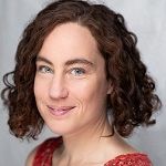 Woman with curly hair in a red dress.