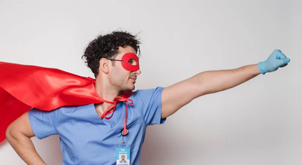 A man doing a super hero pose wearing a red mask and red cape