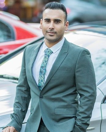 Amit Singh Saini - A decent looking guy wearing a aqua green colored coat with a background of parked cars