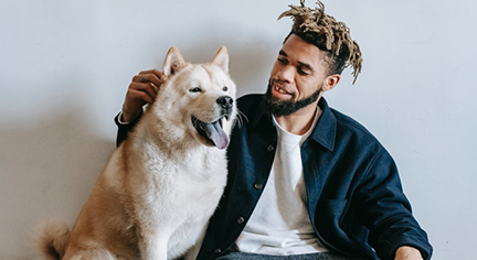 A guy patting his white dog