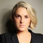 Portrait of Hayley Flowers with a straight face and blonde hair on a beige background