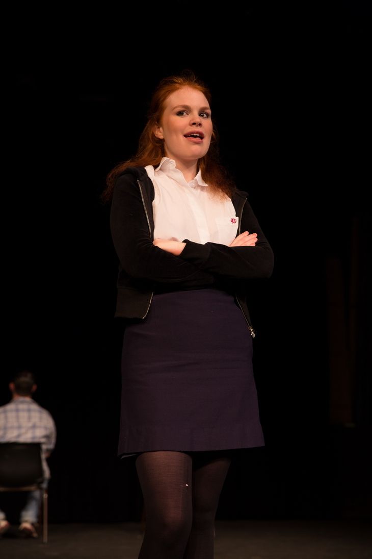 Laughing and Folded arms Blonde girl wearing a white polo, black jacket and navy blue skirt with folded arms