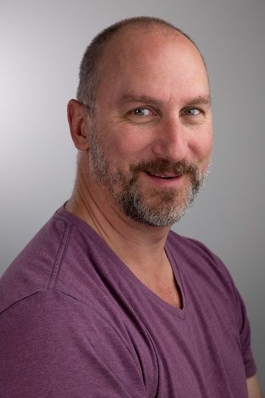 Matt Young - A bald guy with a full grown beard wearing a purple shirt