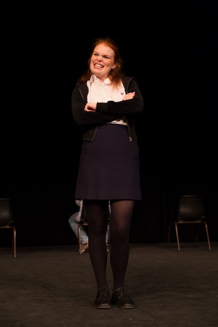 Laughing and Folded arms Blonde girl wearing a white polo, black jacket and navy blue skirt