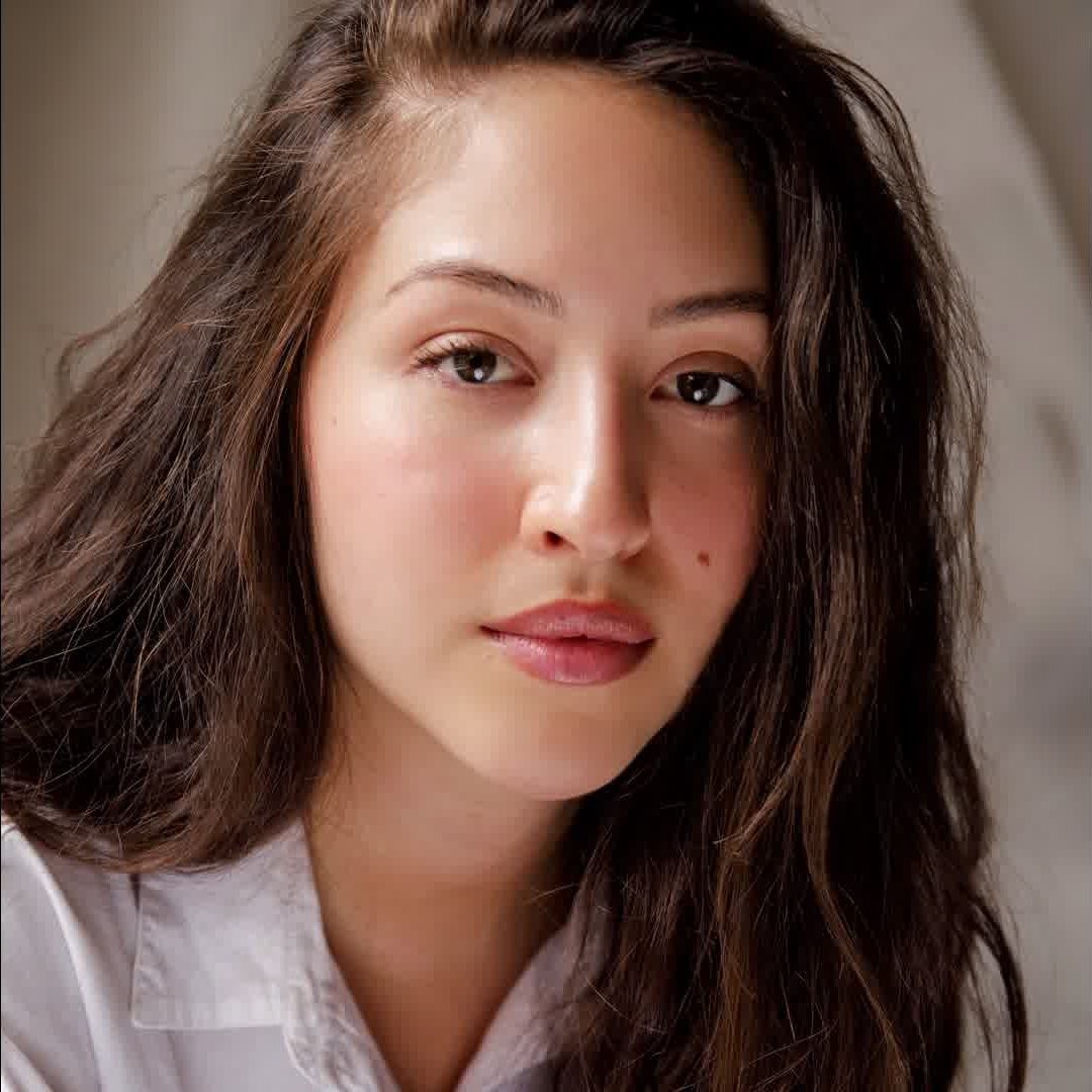 Woman with a long brown hair wearing a white polo