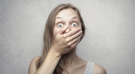 A woman that looks shocked while covering her mouth