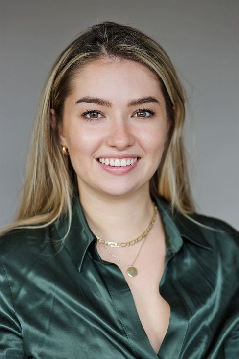 Shauna Griffith, an elegant looking blonde woman wearing a green blouse with a gold necklace