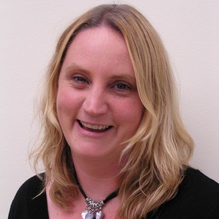 Dr Sally Richards, A blonde woman wearing a black dress with an elegant necklace
