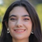 Cris Bocchi, A woman in a black dress with makeup on her face, exuding elegance and confidence.