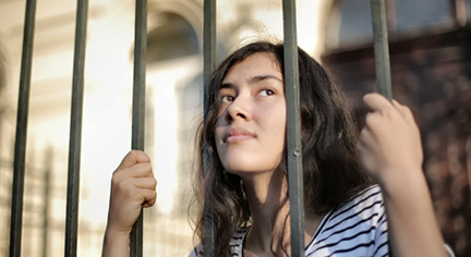 A woman behind cell bars
