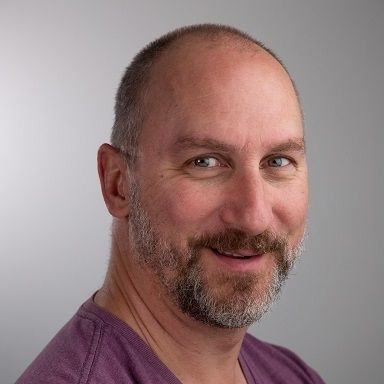 Matt Young - A bald guy with a full grown beard wearing a purple shirt