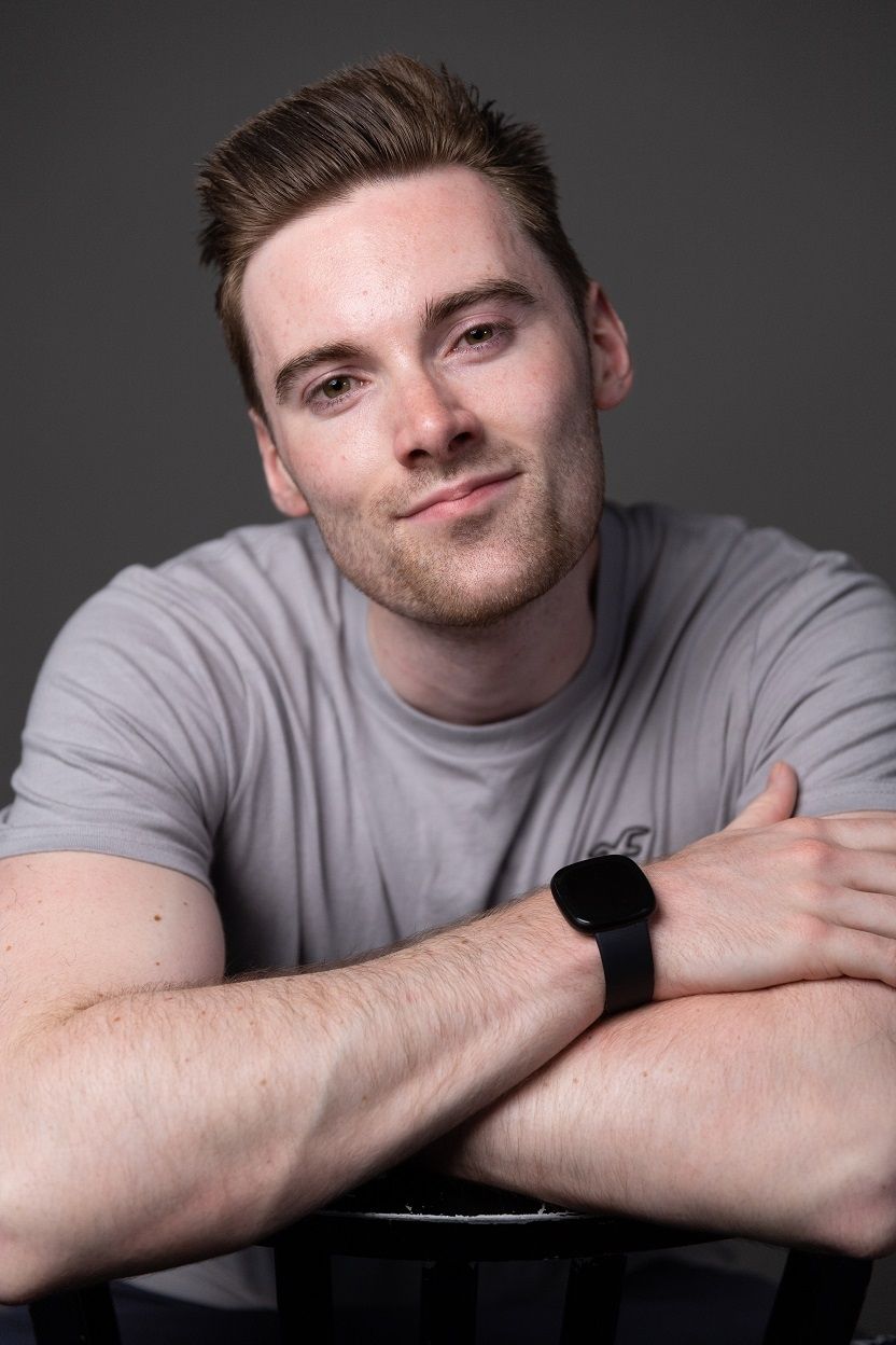 Tim Charles, A white guy wearing a grey shirt and a watch in a folding arms position