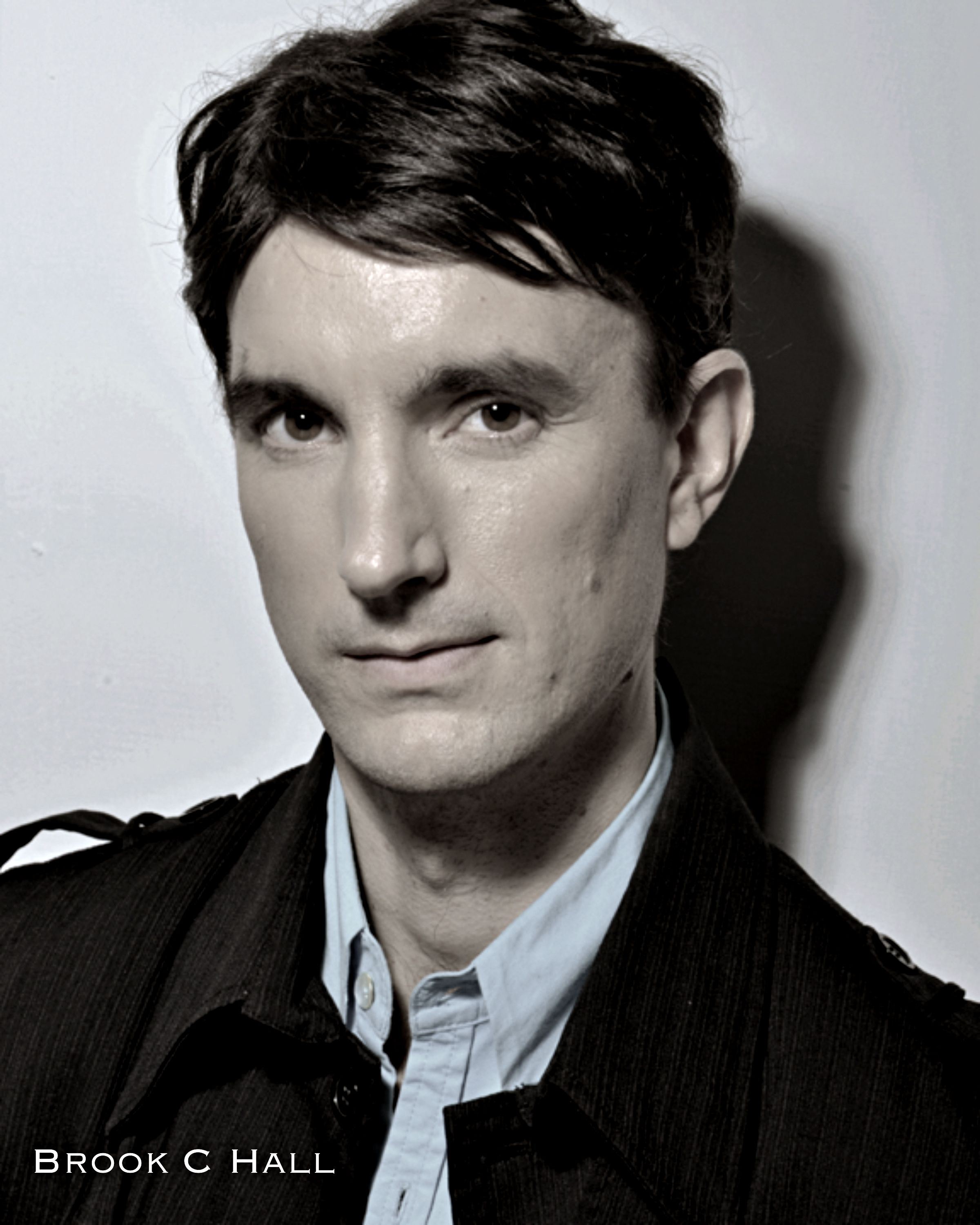 Brook C Hall - Image of a black haired guy wearing a black jacket and light blue polo shirt