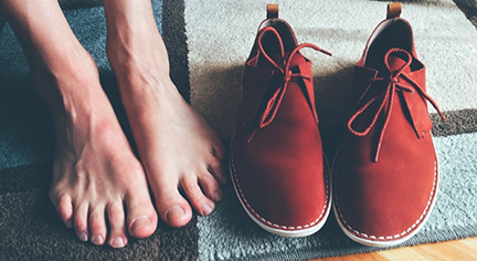 A feet and a pair of red shoes