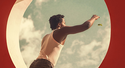 A black guy chasing a bee in the window