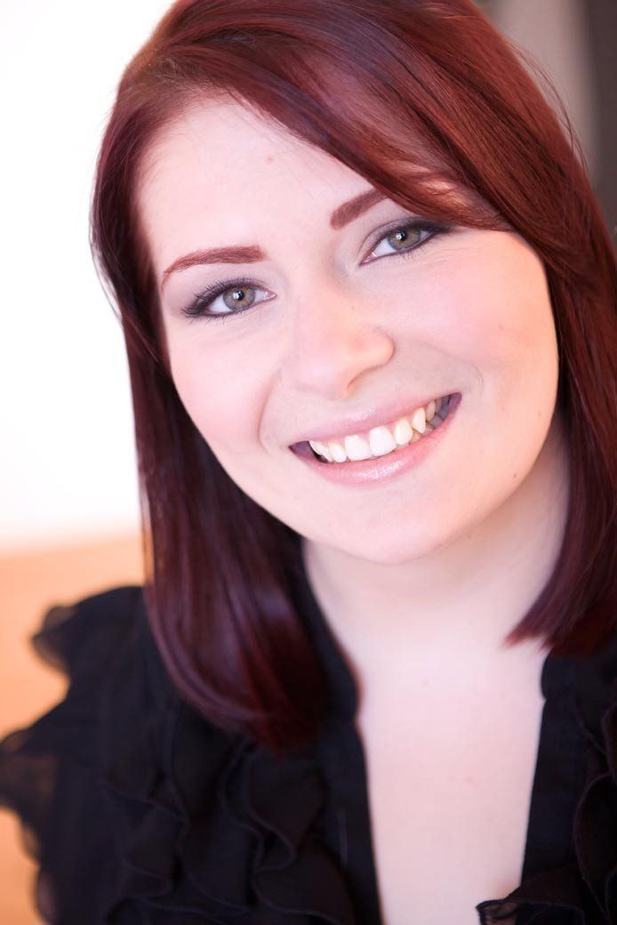 Elyse O'Shaughnessey, A smiling red haired woman wearing a black blouse