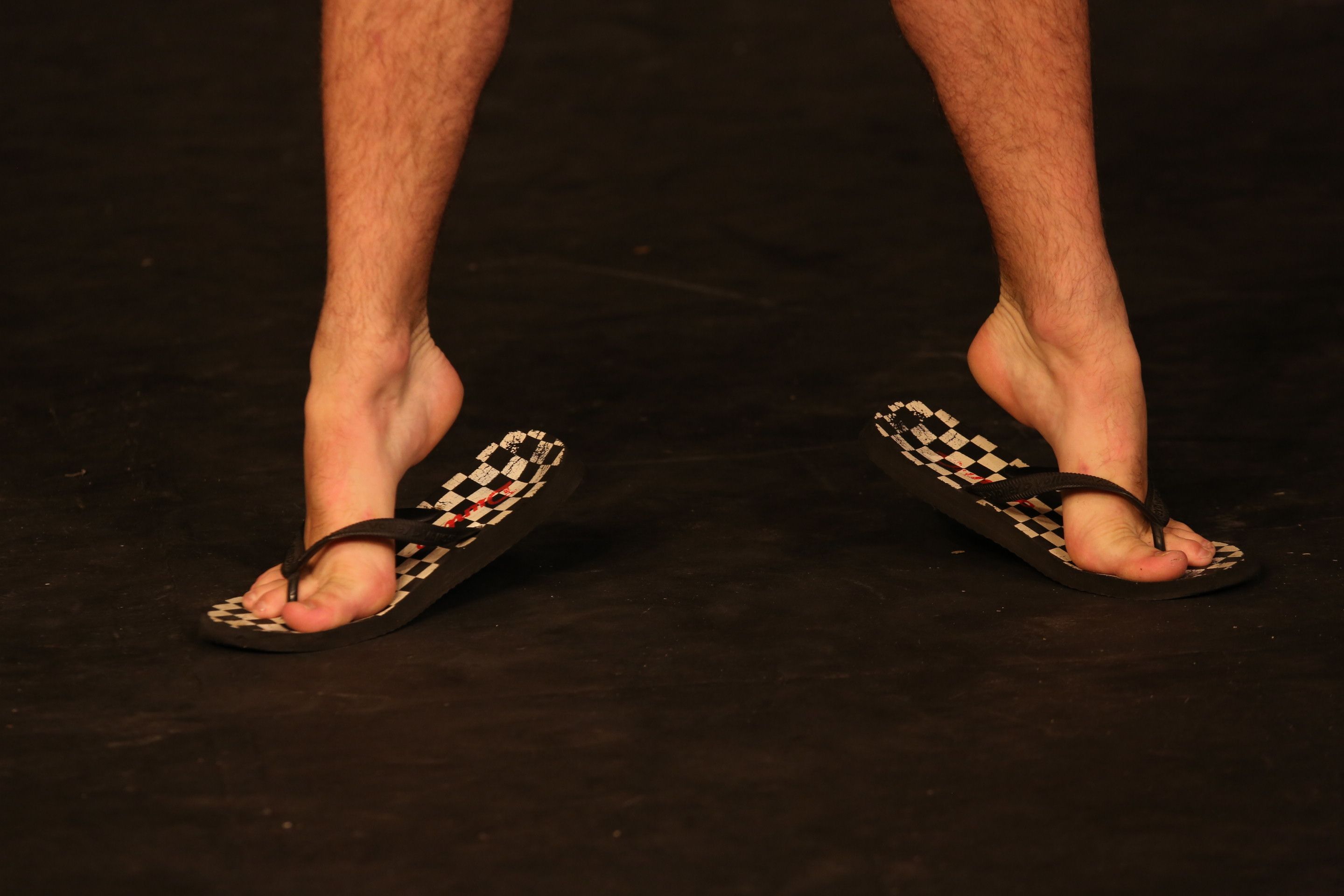 Tip toed feet wearing checkered slippers 