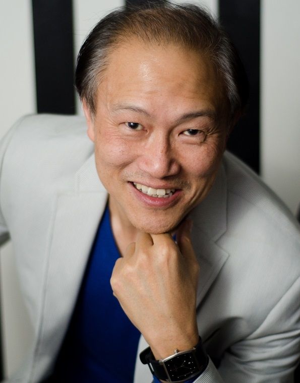 Jon-Clare Lee, A middle aged Asian wearing a grey coat and a blue polo