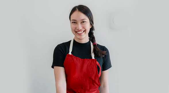 A female wearing a black shirt with apron that has a "coles" logo