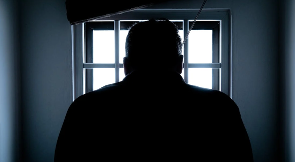 A silhouette of a man behind the window lights