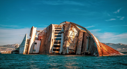 A wrecked ship with half of it's body sinking in the ocean