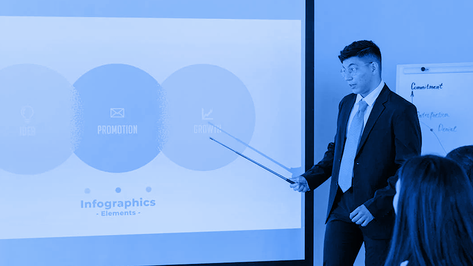 Young man in business attire holding a stick while pointing out a presentation infographics infront of audience