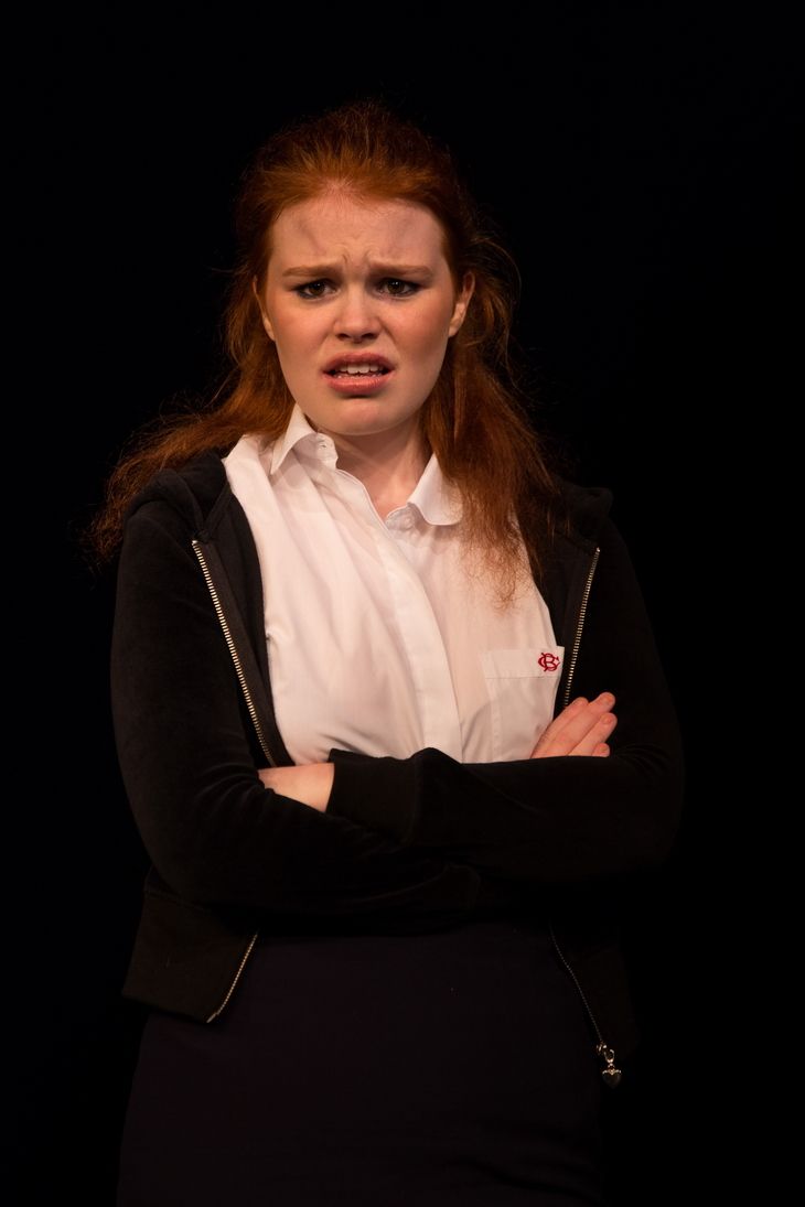 Laughing and Folded arms Blonde girl wearing a white polo, black jacket and navy blue skirt
