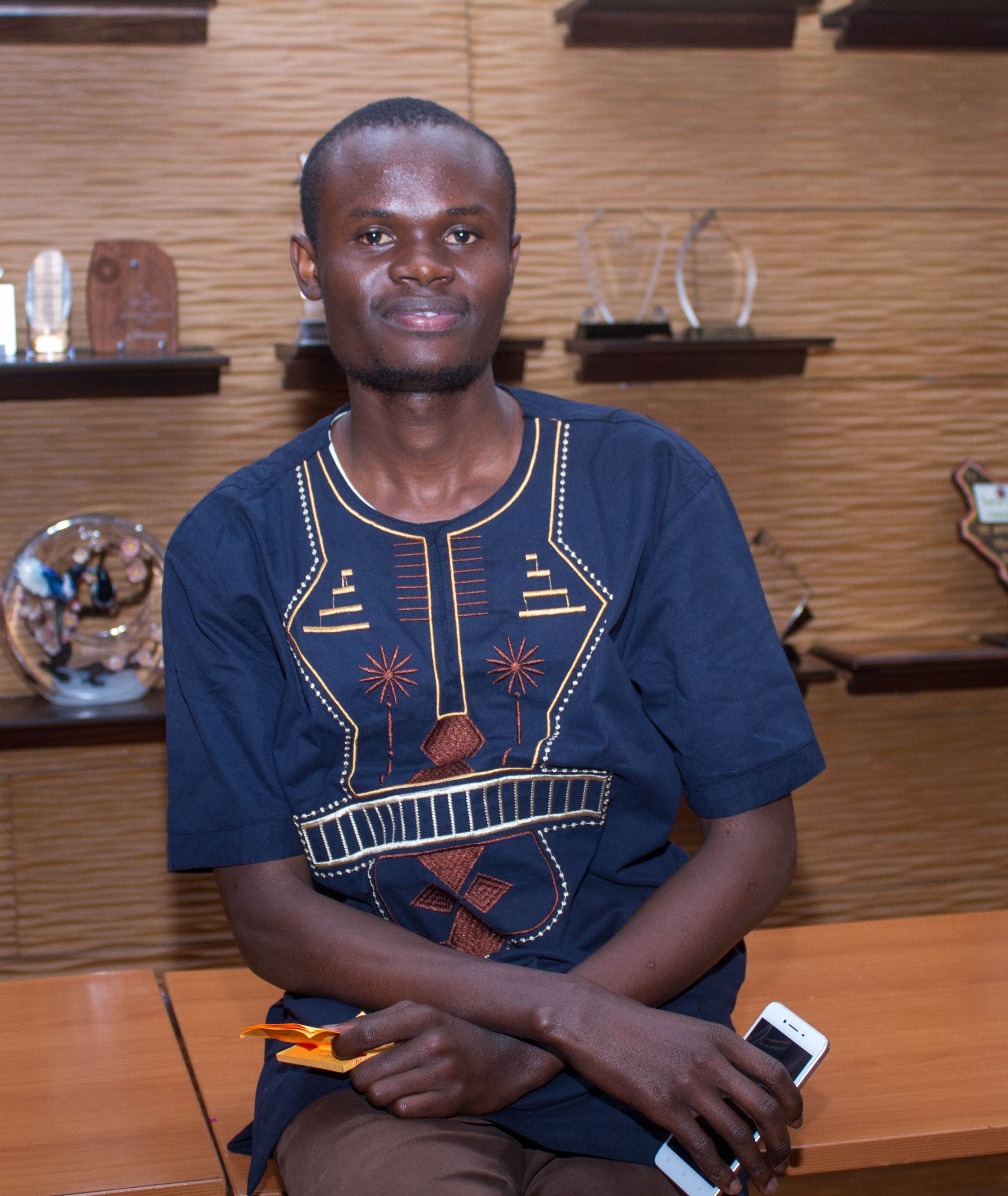 Joseph Obel - An individual relaxing on a wooden chair.