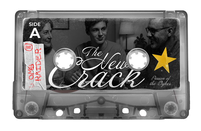 A guy in bed wearing a black leather jacket and pants while reading a book