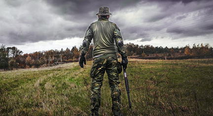 A soldier with a gun in an open field