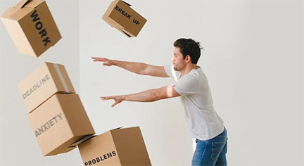 A guy pushing a stack of boxes violently