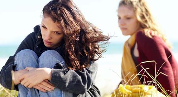 Two Sisters having an argument sitting on a park