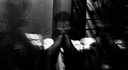 A person covering up his/her face in fear