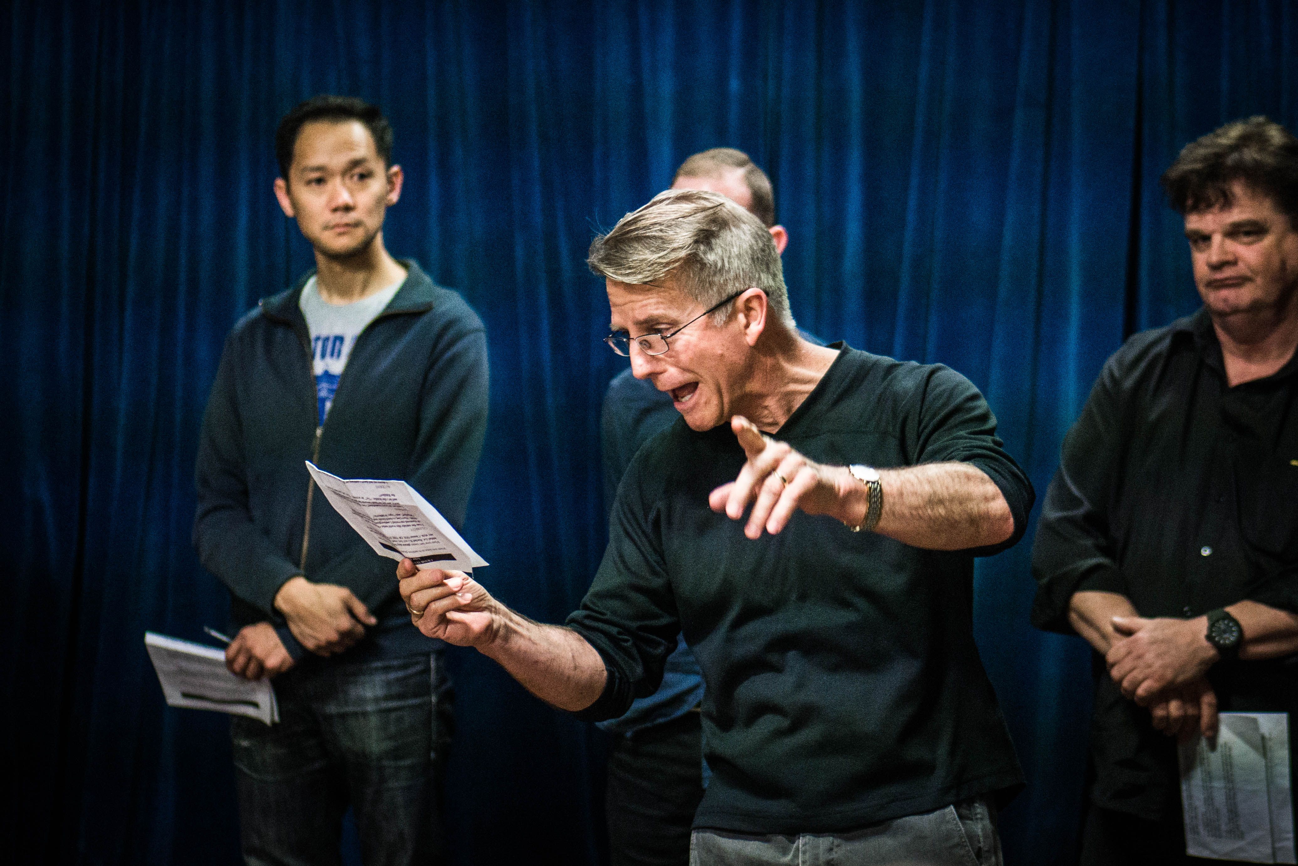 An acting coach reading a script to students