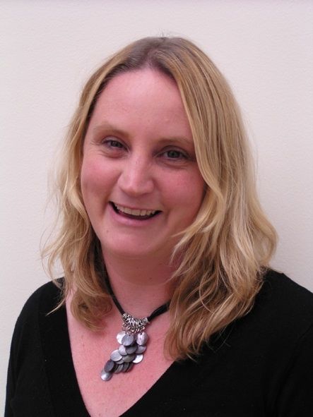 Dr Sally Richards, A blonde woman wearing a black dress with an elegant necklace