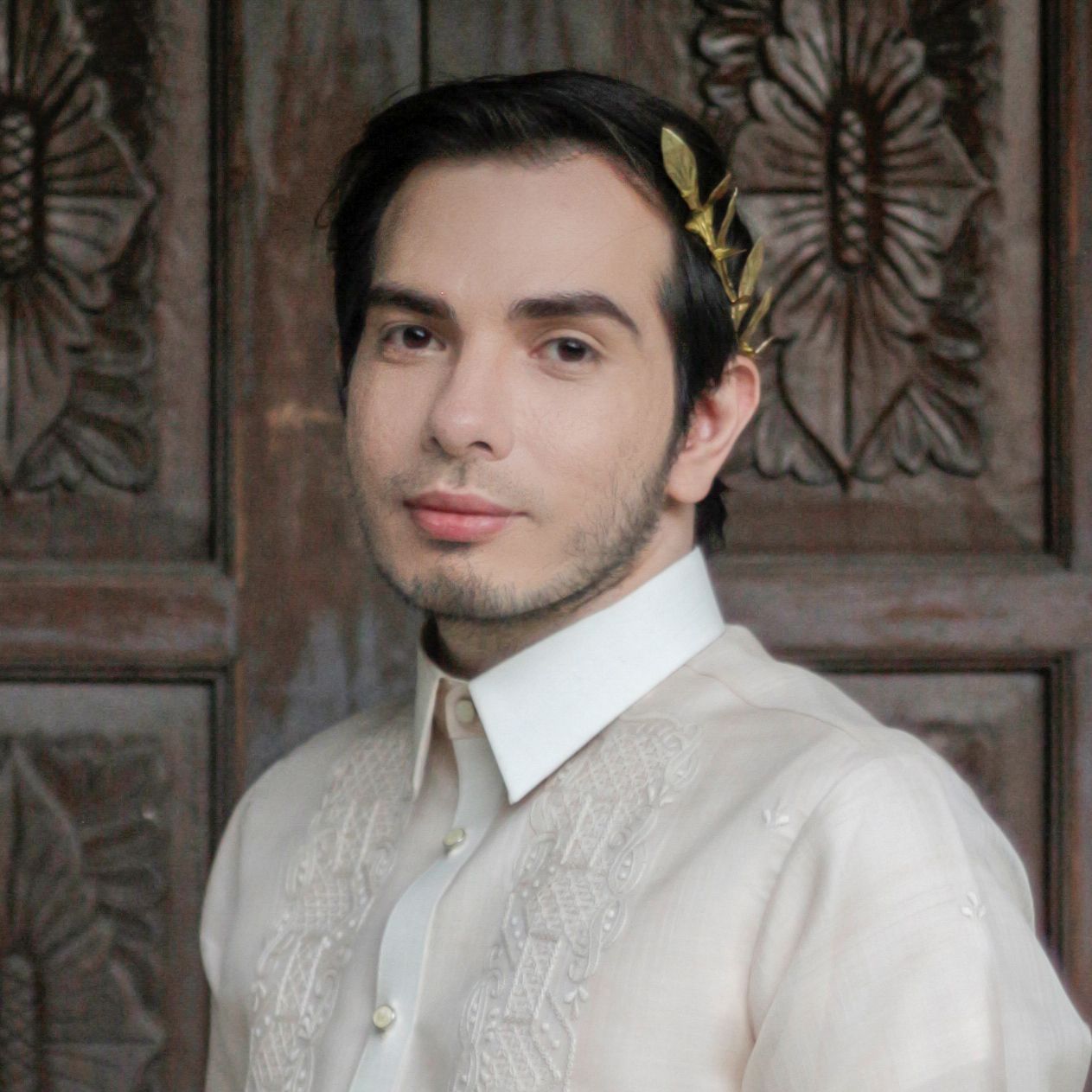 Mark Ghosn - A man in a white Barong and gold headband.