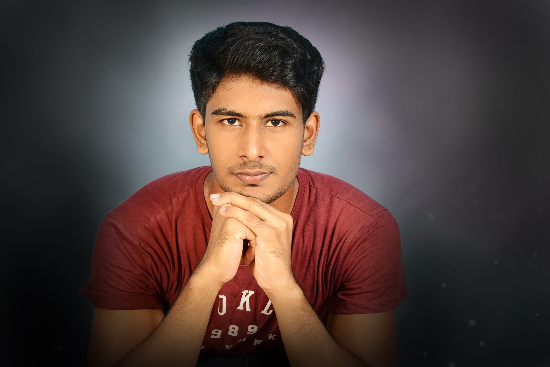 Kapilthev Kanapathipillai - Sri Lankan guy doing a pose wearing a red shirt in a black gradient background