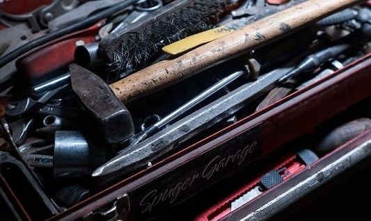 A toolbox with a hammer, pliers and screwdriver