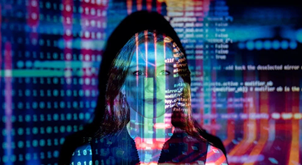 A woman standing infront of a wall with codes reflected to her face